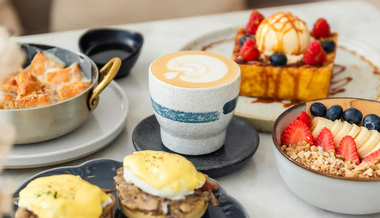Brunch dishes and a latte on a café table